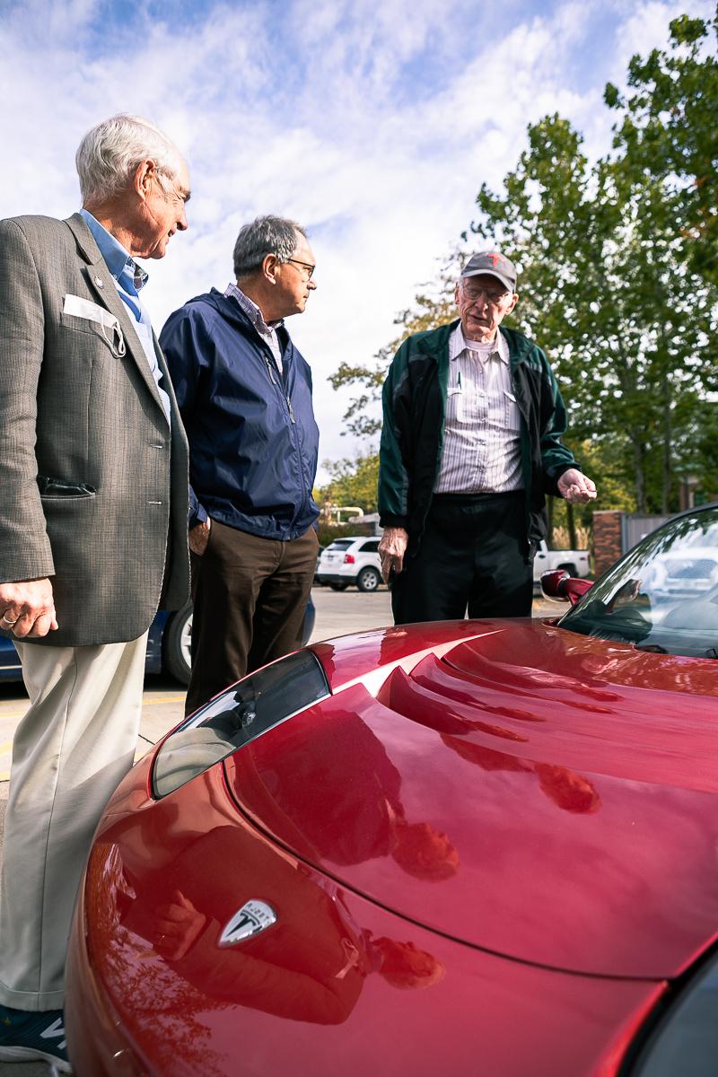Dr. 唐·考克斯博士. 拉斯·苏切克和肯·哈尔一起站在考克斯的红色特斯拉跑车旁边. 
