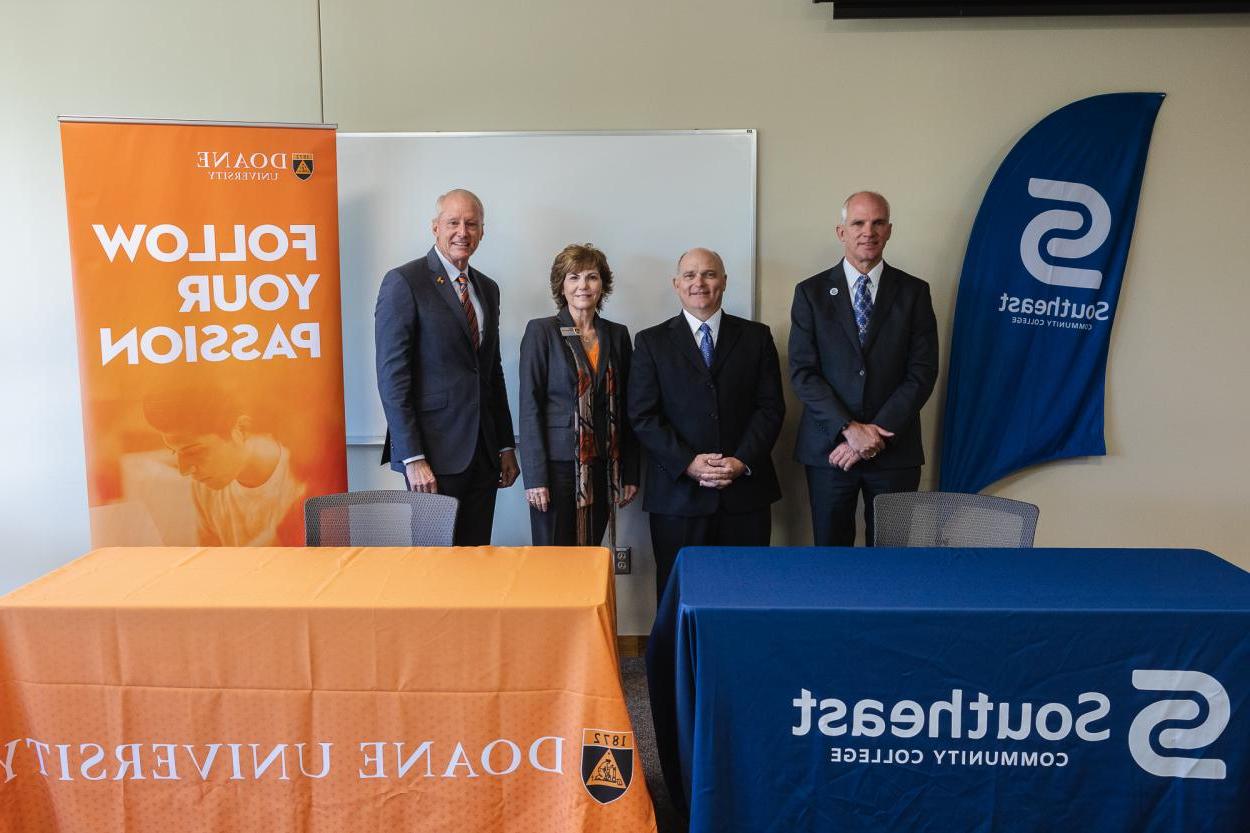 Representatives from Southeast Community College and Doane University stand behind branded materials to celebrate the signing of an institutional agreement between the two institutions. 