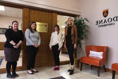 心理咨询学院文学硕士吉恩·基尔诺斯基, 考特尼东, Arden Szepe和Andrea McGrath站在Doane林肯校区的项目办公室外.